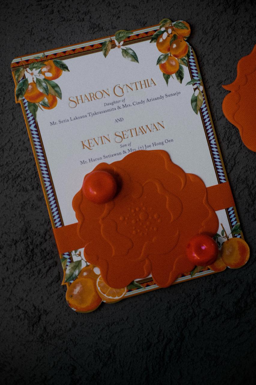 Bold orange wedding invitation with citrus illustration and wax seal