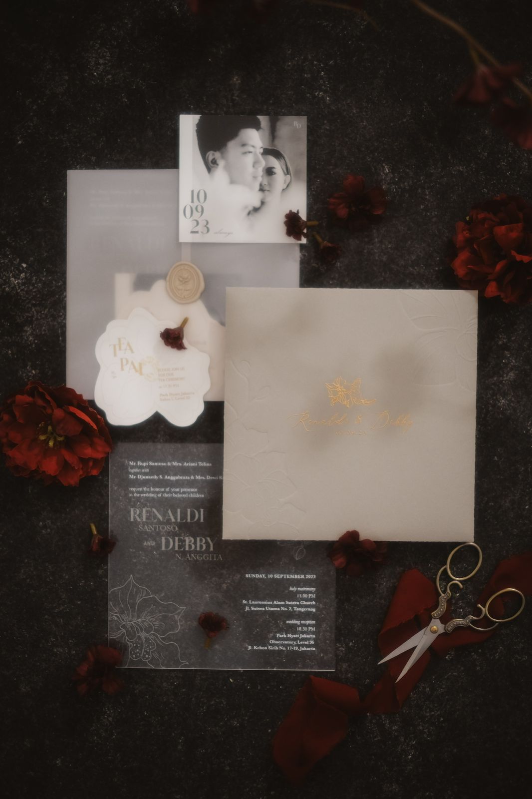 Acrylic wedding invitation suite with gold foil and wax seal on dark linen